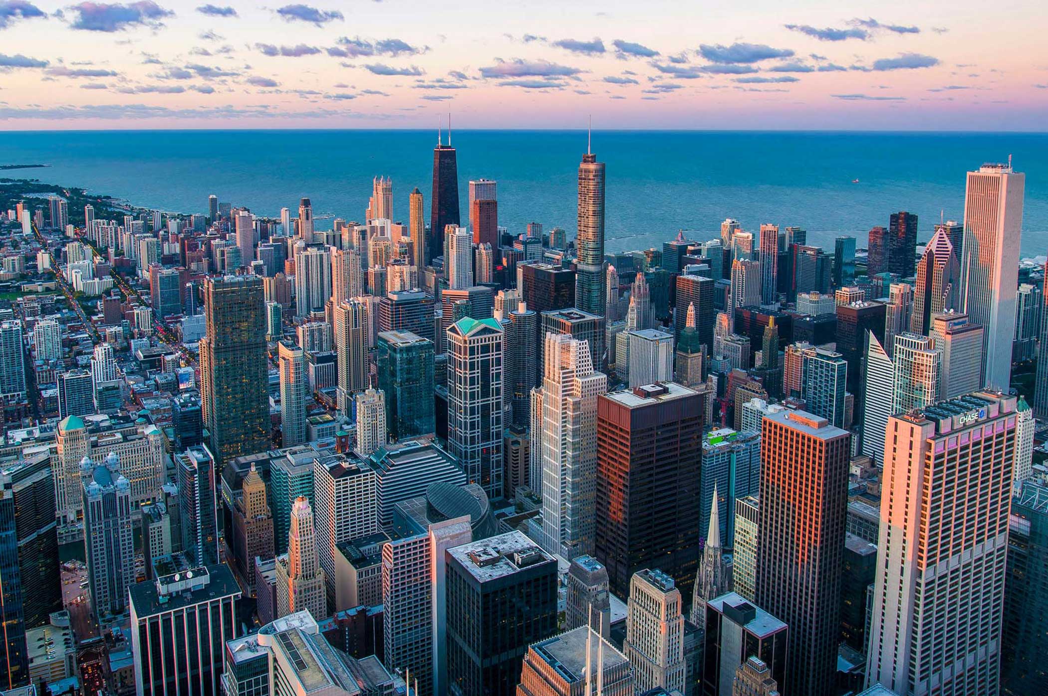 Contact Summit Electrical Group for commercial electrical projects across major city markets, shown with downtown skyscrapers, Lake Michigan, and a sunset sky.